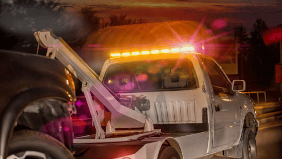 Towing truck on the move at night with the lights and siren on